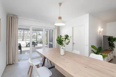 a dining room with a wooden table and white chairs at The Albufeira Concierge - Casa IÊ in Albufeira