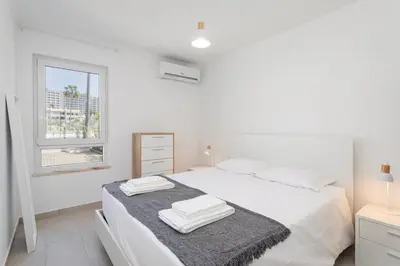 a white bed with white sheets and a pillow at The Albufeira Concierge - Casa IÊ in Albufeira