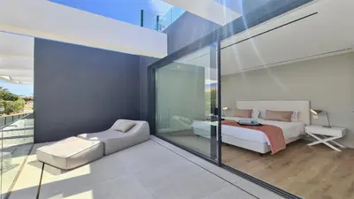 a bedroom with a king sized bed and a chair at OneSixOne-Cleverdetails, Luxury villa, Sleeps 8 adults 2 children, Private pool and Jacuzzi in Vilamoura