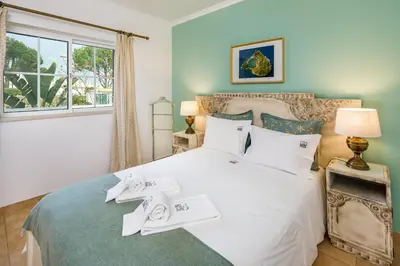 a bedroom with a bed with towels on it at Falésia Ocean Villa by The Portuguese Butler in Albufeira