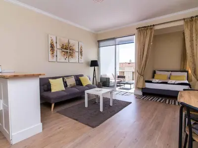 a living room with a couch and a table at Sea View Studio by Stay ici Algarve Holiday Rental in Albufeira