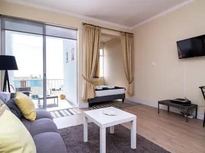 a living room with a couch and a table at Sea View Studio by Stay ici Algarve Holiday Rental in Albufeira