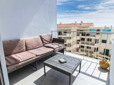 a couch and a table on a balcony with a building at Sea View Studio by Stay ici Algarve Holiday Rental in Albufeira