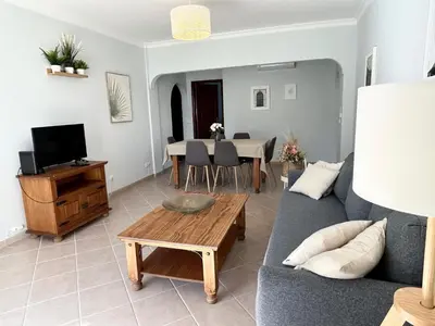 a living room with a couch and a table at Albufeira 3BR with Pool and AC by the beach by LovelyStay in Albufeira