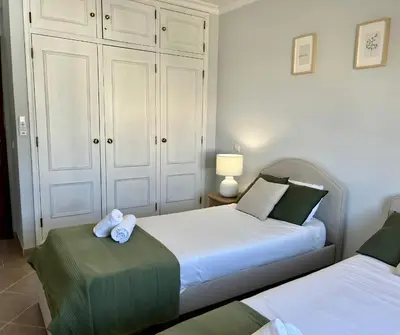 a bedroom with two beds with towels on them at Albufeira 3BR with Pool and AC by the beach by LovelyStay in Albufeira