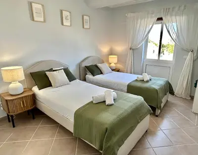 a bedroom with two beds and a window at Albufeira 3BR with Pool and AC by the beach by LovelyStay in Albufeira