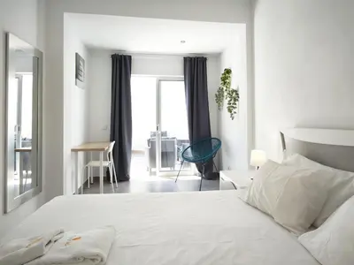 a white bedroom with a white bed and a window at Old Town II Apartment by Stay ici Algarve Holiday Rental in Albufeira