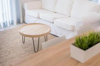 a living room with a white couch and a table at Apartamentos Baltum in Albufeira