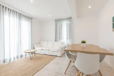a white living room with a white couch and a table at Apartamentos Baltum in Albufeira
