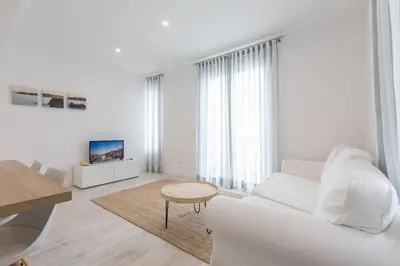 a white living room with a white couch and a table at Apartamentos Baltum in Albufeira