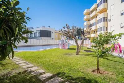 a bedroom with a large white bed with towels on it at Solbelo Quarteira Beach in Quarteira