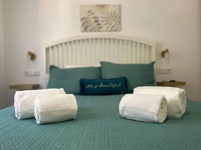 a bedroom with a bed with two slippers on it at Solbelo Quarteira Beach in Quarteira