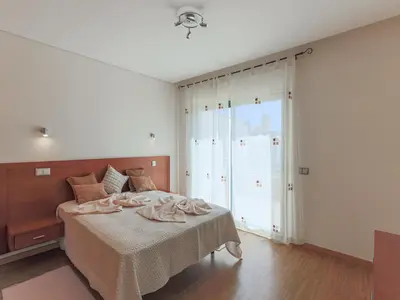 a bedroom with a bed and a large sliding glass door at V4, Villa Jardins Branqueira7 near Beach, Albufeira in Albufeira