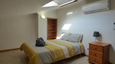 a bedroom with a bed with a backpack on it at Large Duplex Apartment Pool View in Albufeira