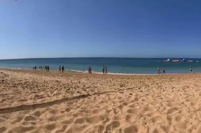 a group of people walking on the beach at ALEXA APARTMENT T2, Albufeira Center two bedrooms Self check-in in Albufeira