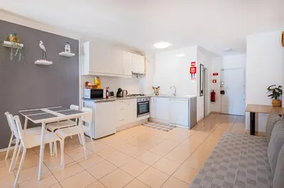 a kitchen with white cabinets and a table and chairs at Beach Studio in Albufeira's old town in Albufeira