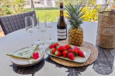 a table with a plate of strawberries and wine glasses at Luxury Villa in Serene Location with Pool & Private Garden in Quarteira