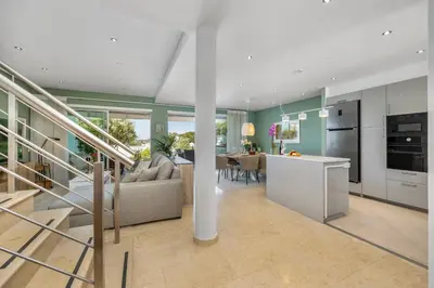 a kitchen and living room with a couch and a table at Luxury Villa in Serene Location with Pool & Private Garden in Quarteira