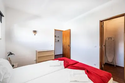 a bedroom with a bed with a red blanket on it at BeGuest Albufeira Visconde Apartment in Albufeira