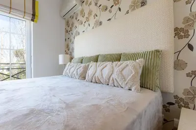 a bedroom with a large white bed with pillows at ROJA PÉ - Elegante apartamento T2 com AC perto do Pine Cliffs in Albufeira