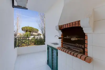 a kitchen with a brick oven with a window at ROJA PÉ - Elegante apartamento T2 com AC perto do Pine Cliffs in Albufeira
