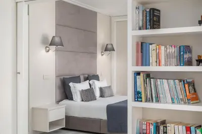 a bedroom with a bed and a book shelf with books at D_Loft in Albufeira