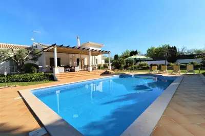 a swimming pool in front of a house at Villa Jóia - 3 Bedroom Villa with Swimming pool in Boliqueime, near Vilamoura, Algarve in Boliqueime
