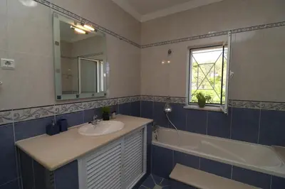 a bathroom with a sink and a tub and a mirror at Villa Jóia - 3 Bedroom Villa with Swimming pool in Boliqueime, near Vilamoura, Algarve in Boliqueime