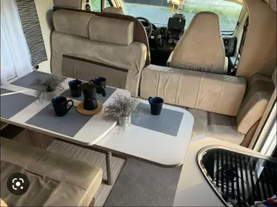 a camper van with two tables and a couch at Portugals Infinity - AutoCaravana Luxo in Faro