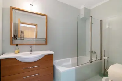 a bathroom with a sink and a shower and a mirror at Sunset House Algarve in Faro