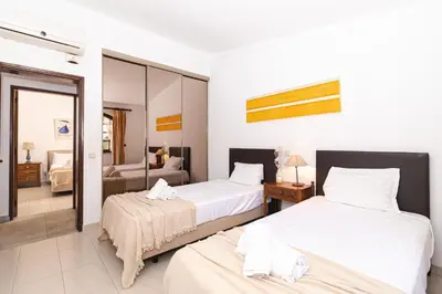 a hotel room with two beds and a mirror at Villa Fineli in Vilamoura