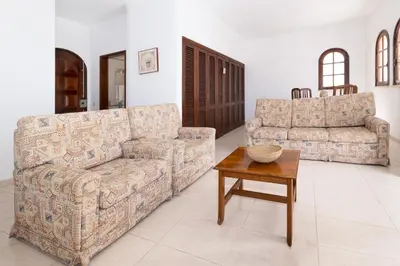 a living room with two couches and a table at Villa Fineli in Vilamoura
