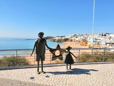 a statue of a boy and a girl holding a kite at Albufeira-Sea View/pool Casa Sara Linnea 1bedroom in Albufeira