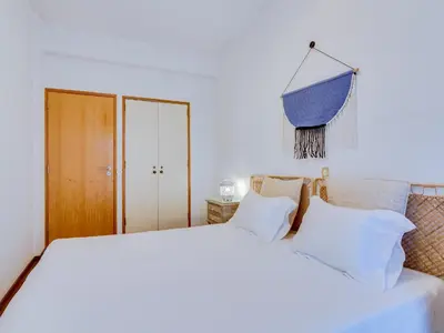 a bedroom with a large white bed with white pillows at AL - Apartamento Maré Alta in Quarteira