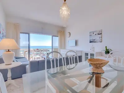 a living room with a glass table and chairs at AL - Apartamento Maré Alta in Quarteira