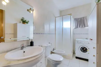 a white bathroom with a toilet and a sink at Nascente Sea View @Homesbyfc in Quarteira