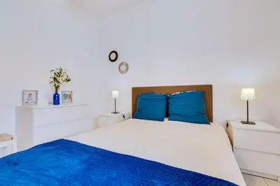 a bedroom with a large bed with blue pillows at Nascente Sea View @Homesbyfc in Quarteira