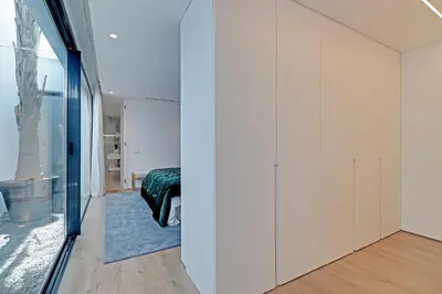 a bedroom with white walls and a sliding glass door at One Six Villa in Vilamoura