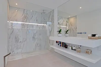 a white bathroom with a shower and a sink at One Six Villa in Vilamoura
