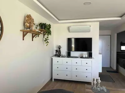 a living room with a white dresser with a flat screen tv at Casa Linda in Albufeira