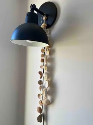 a black lamp with shells on a wall at Casa Linda in Albufeira