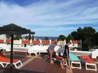 two men walking on the roof of a house at Casa Linda in Albufeira