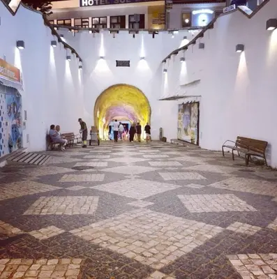 a hallway of a building with people walking through a tunnel at Casa Linda in Albufeira