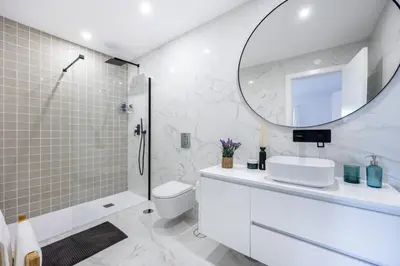 a white bathroom with a sink and a mirror at Alfamar Inês Apartment in Albufeira
