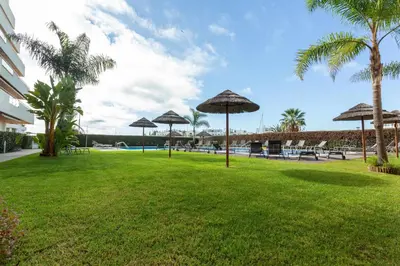 a park with umbrellas and tables and a pool at Marina Vilamoura - Aquamar 005 By Vilamoura Sun in Quarteira