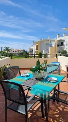 a table with four chairs and a bowl on a patio at ALBUFEIRA TRADICIONAL BEACH APARTMENT in Albufeira