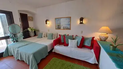 a living room with a red couch and a chair at ALBUFEIRA TRADICIONAL BEACH APARTMENT in Albufeira