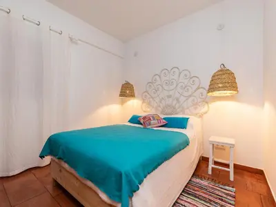 a bedroom with a bed with blue sheets and two lights at Akisol Albufeira Euphoria in Albufeira
