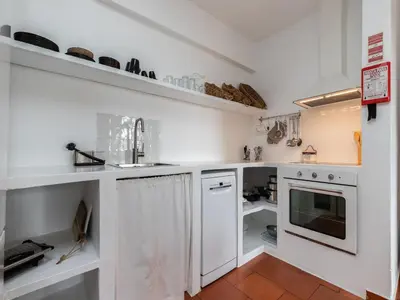 a kitchen with white cabinets and a sink at Akisol Albufeira Euphoria in Albufeira