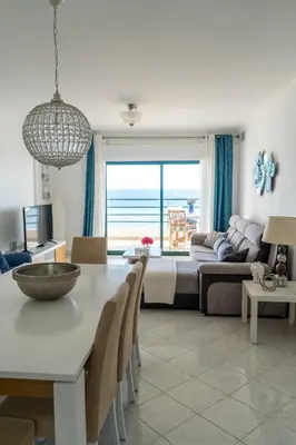 a living room with a table and a couch at Ocean Blue II in Quarteira